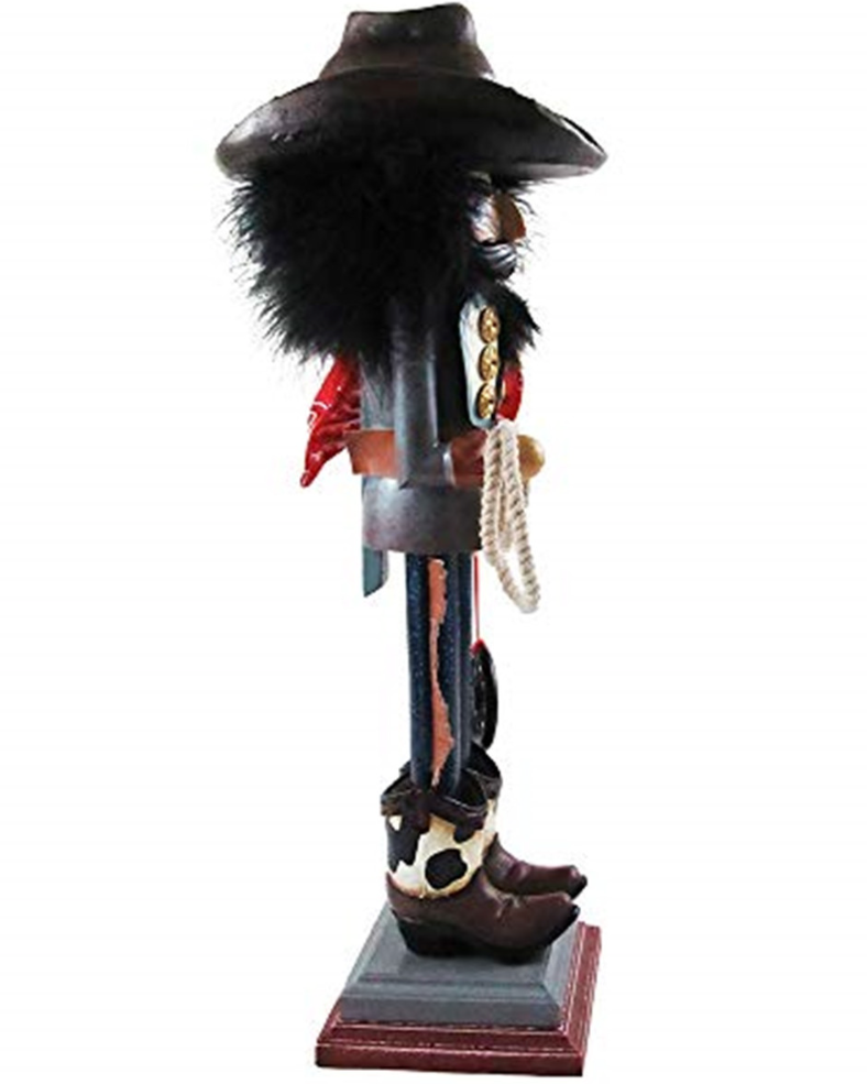 Christmas Cheer All Year A cowboy-themed nutcracker wearing a black wide-brim hat with black buckle detail, a red bandana, jeans with fringe, and brown holstein cowboy boots, standing on a small pedestal
