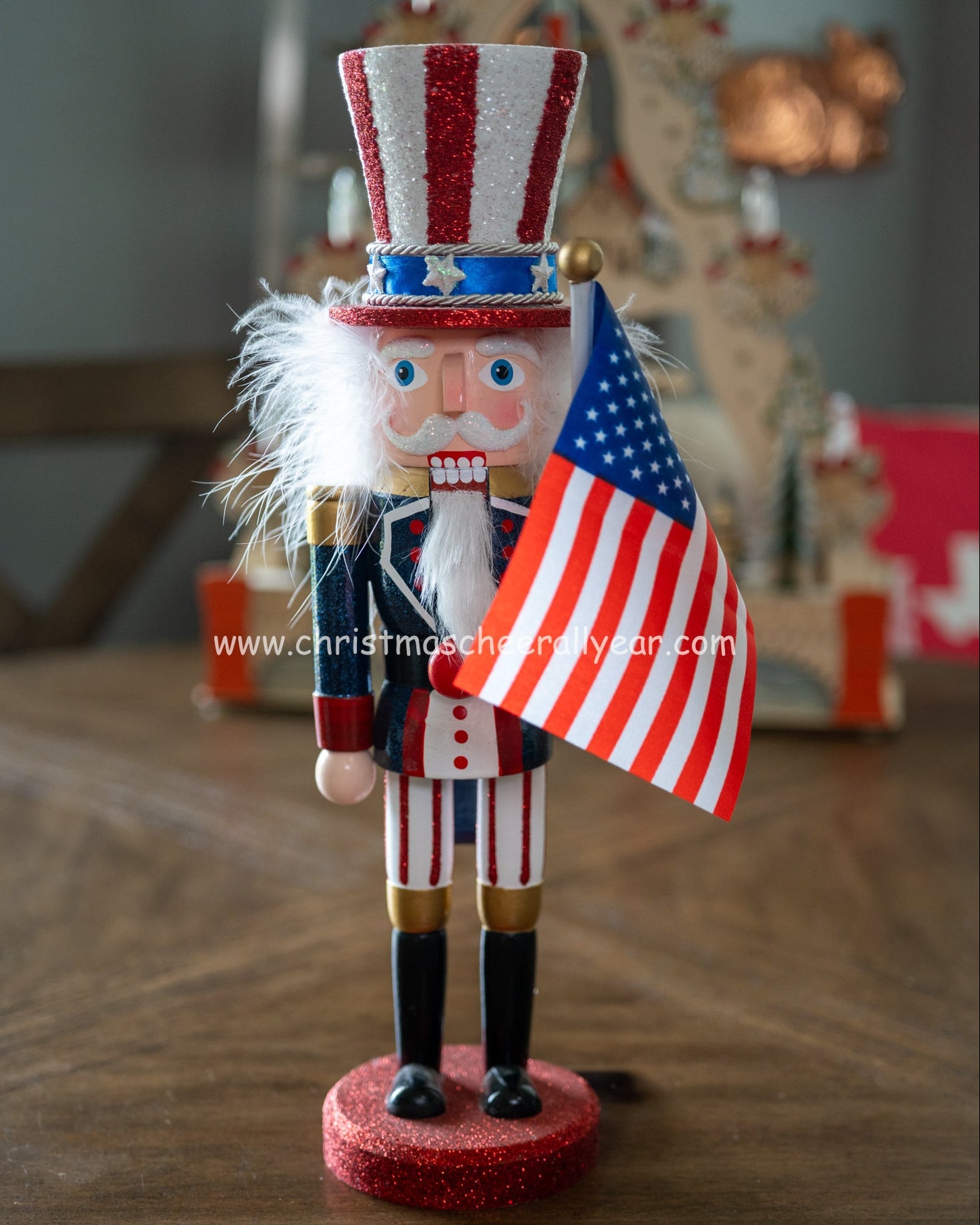 Christmas Cheer All Year Kurt Adler Uncle Sam Wooden nutcracker figure with American flag and top hat on a wooden surface.