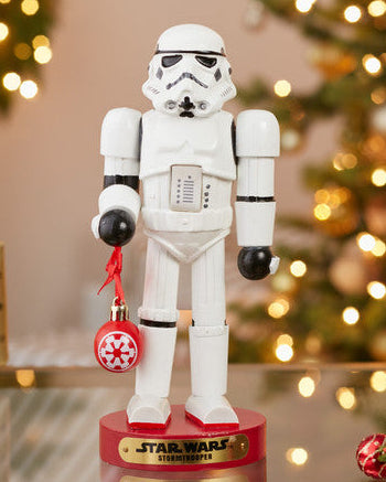 Christmas Cheer All Year Officially Licensed Star Wars Stormtrooper Nutcracker with a Christmas ornament by Kurt Adler in front of a decorated tree