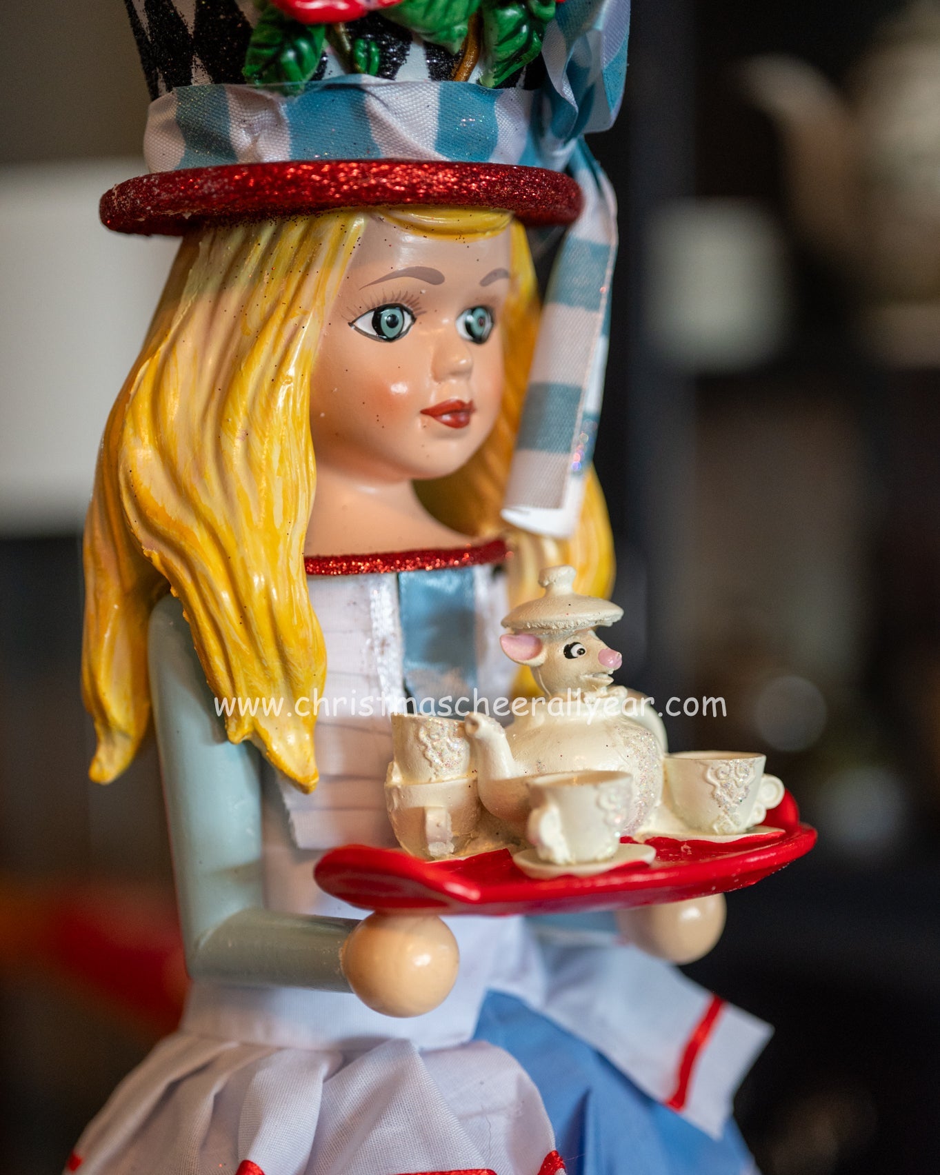 Decorative Alice in Wonderland Hollywood Nutcracker from a children's book with a checkered hat and a tray of items.
