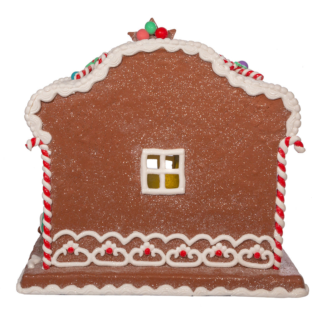 Rear view of Nativity Gingerbread house with decorative elements on a white background