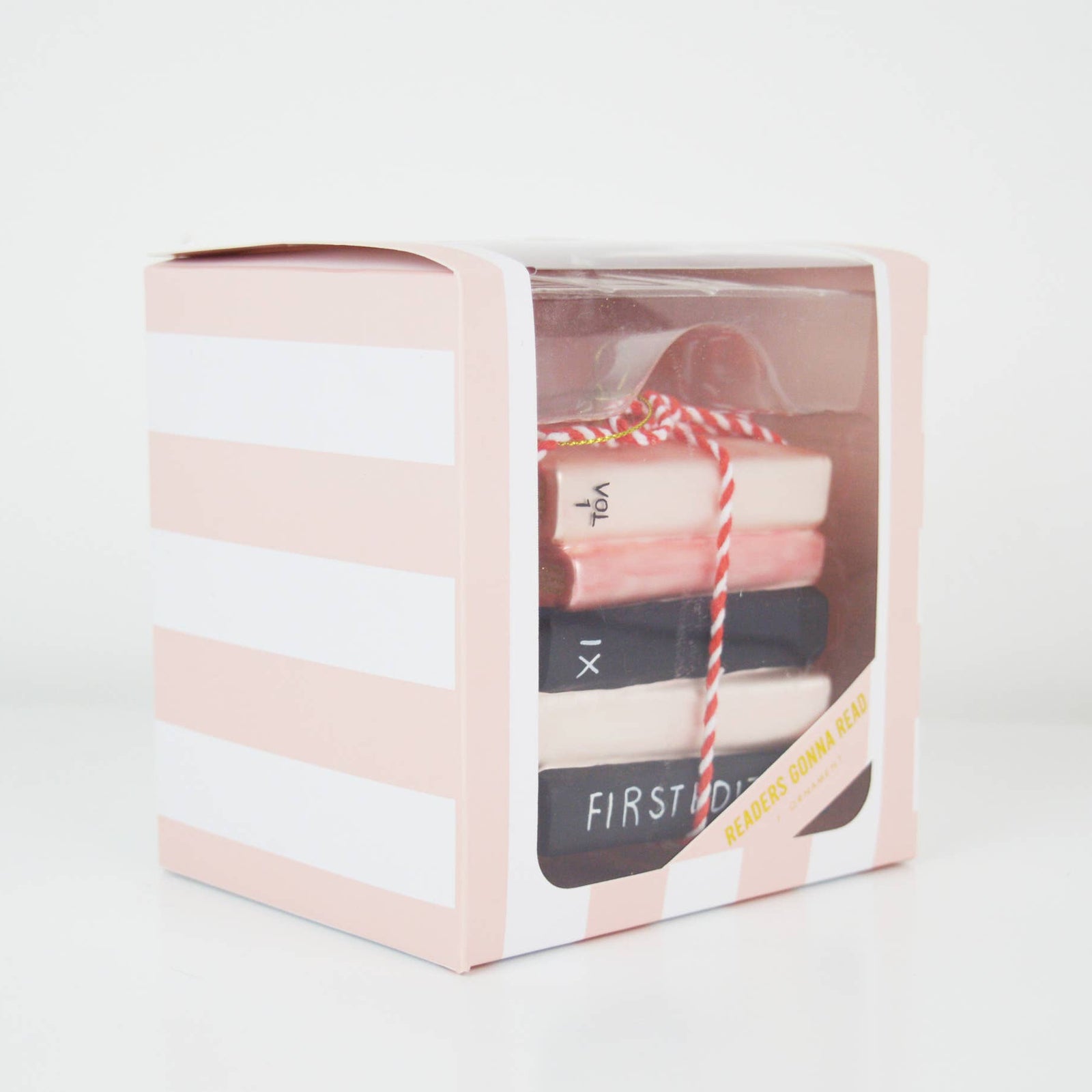 Christmas Cheer All Year Stack of decorative books ornament tied with red and white string on a white background