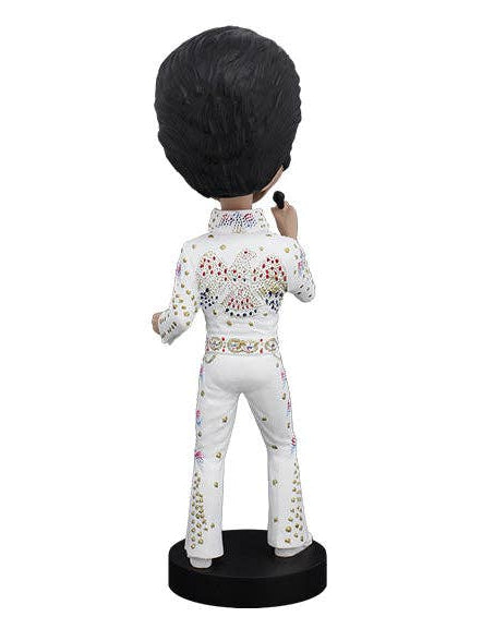 Christmas Cheer All Year bobblehead figurine of Elvis Presley shown from the back, wearing a white jumpsuit with colorful rhinestone embellishments and a black pompadour hairstyle, standing on a black circular base against a white background.