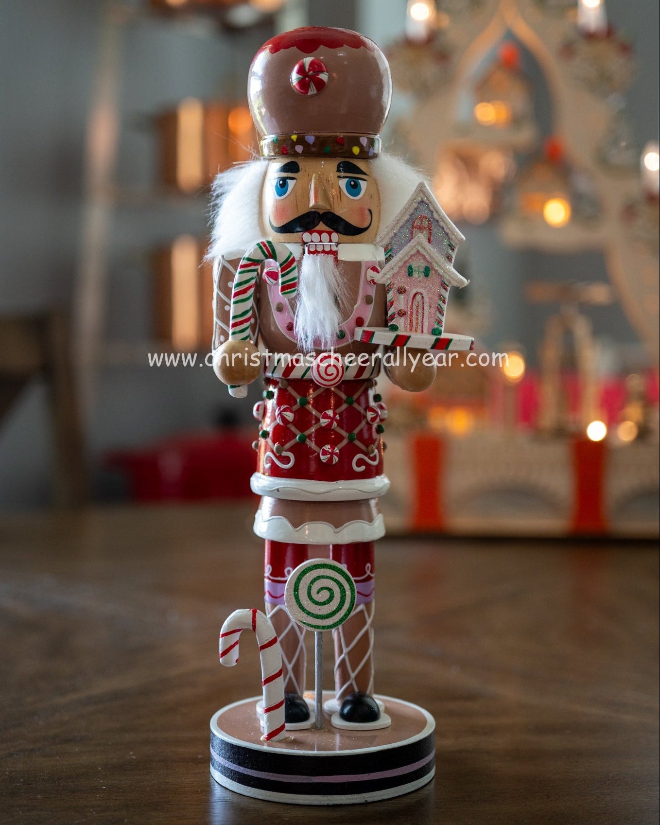 Christmas Cheer All Year Gingerbread Soldier Baker nutcracker with candy cane and gingerbread house and candy cane Kurt Adler all year display