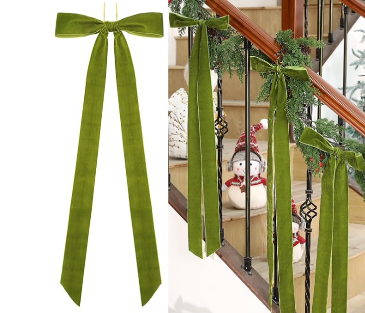 Green velvet ribbon bows on a staircase railing with Christmas decorations.