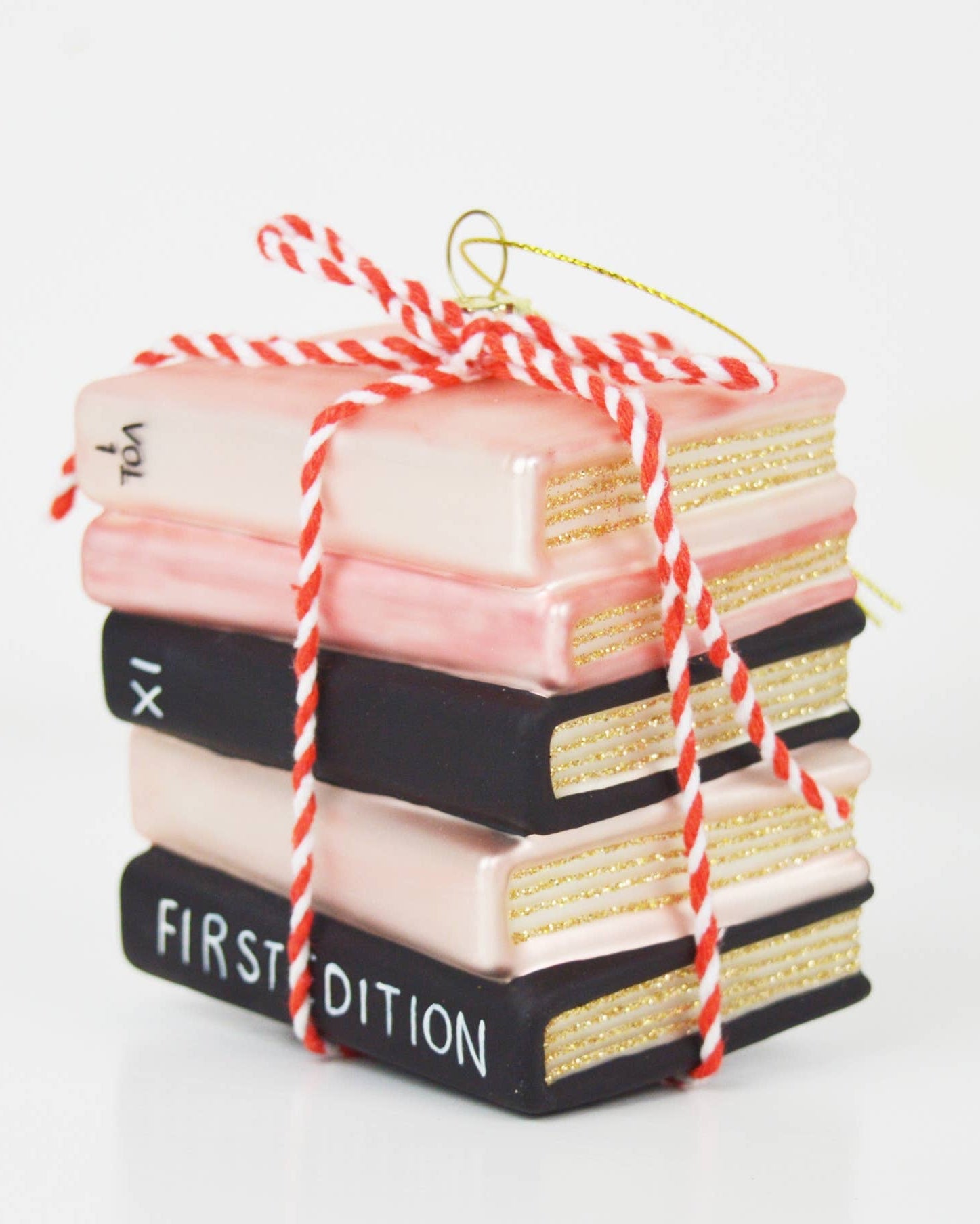 Christmas Cheer All Year Stack of decorative books ornament tied with red and white string on a white background