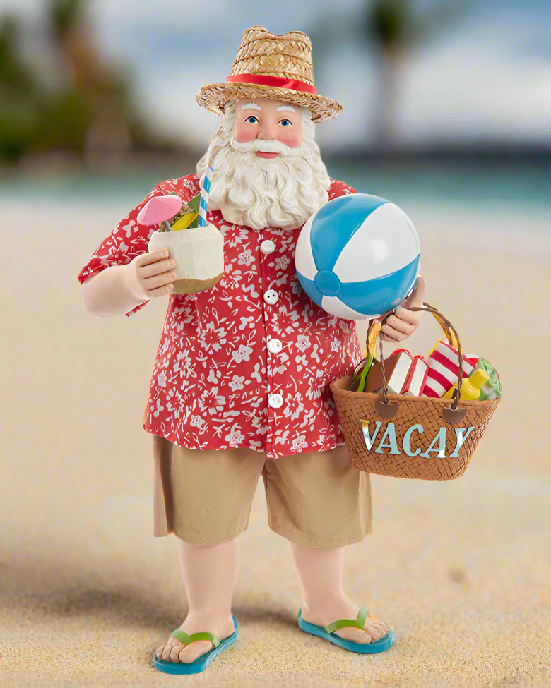 Christmas Cheer All Year Kurt Adler Fabriche Santa Claus figure on a beach holding a drink, beach ball, and 'VACAY' basket.