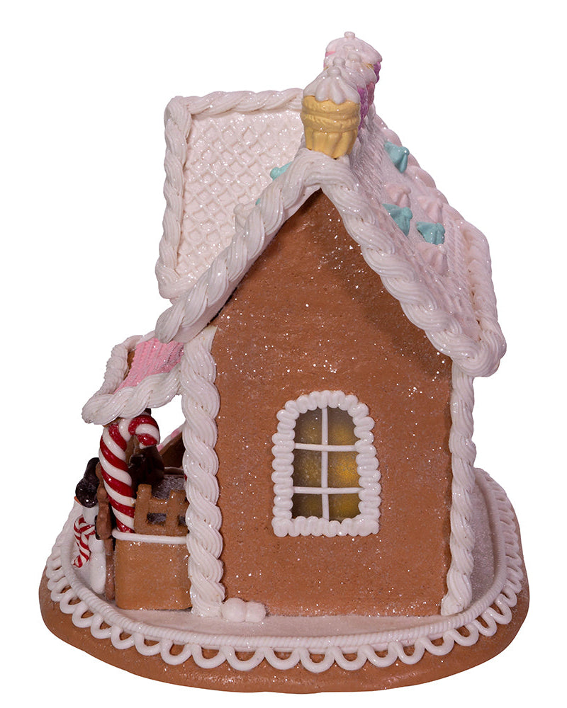 Decorative gingerbread house with a candy cane and ice cream cone on a white background