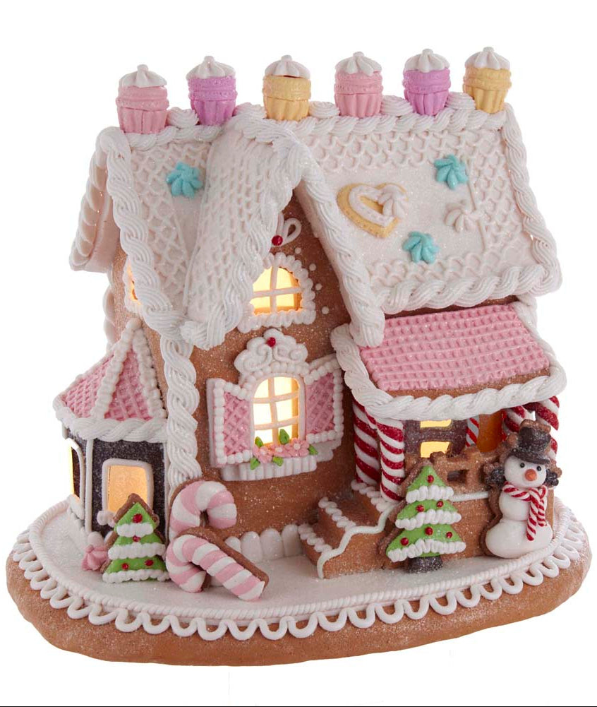 Kurt Adler pink frosted gingerbread house with candy decorations on a white background