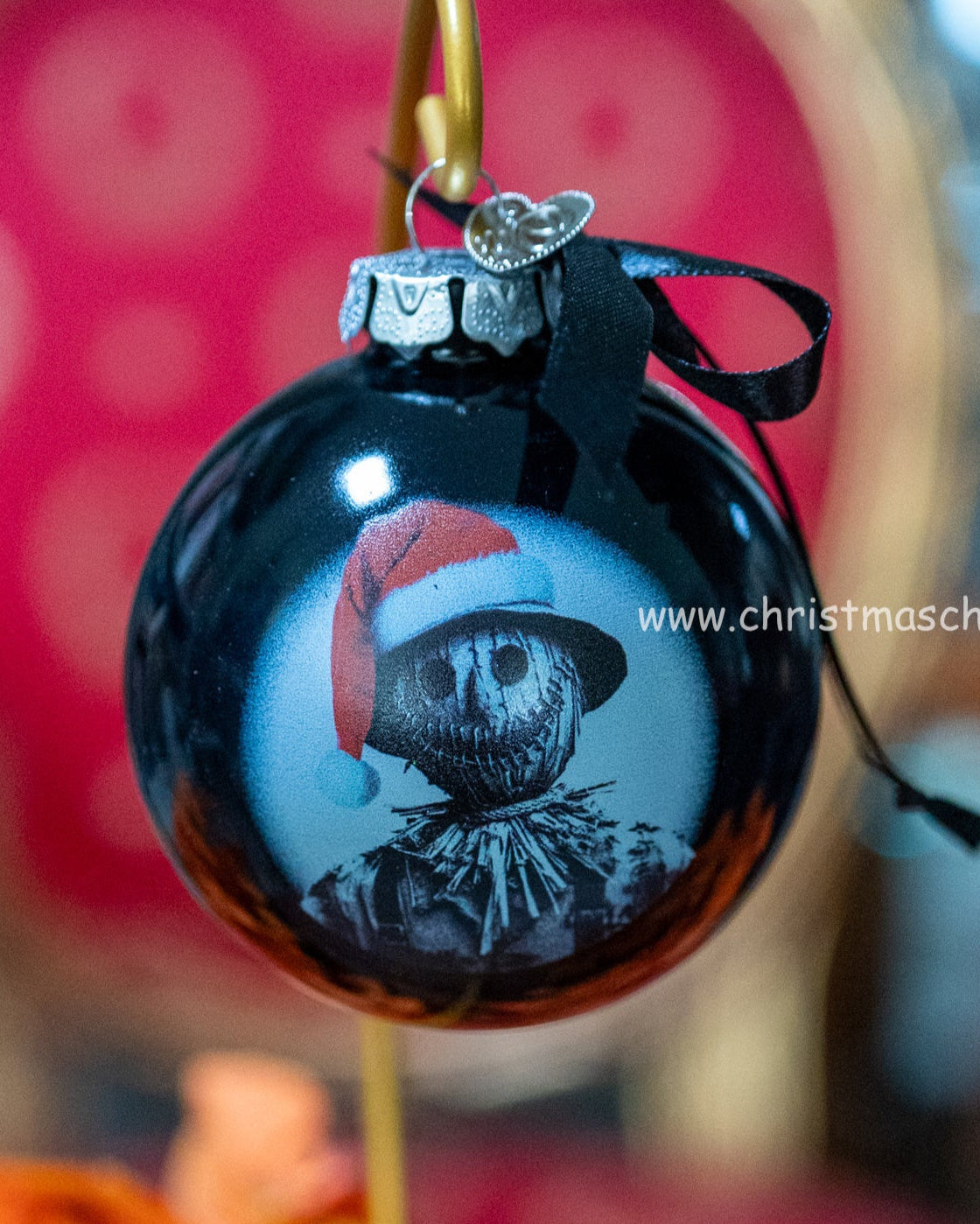 Black Christmas ornament with a scarecrow wearing a Santa hat on a blurred background Christmas Cheer All year