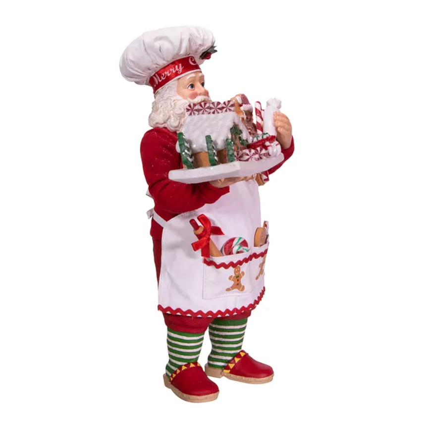 The Canton Christmas Shop 10.5" Fabriché™ Gingerbread Chef Santa with Gingerbread House and Piping Bag