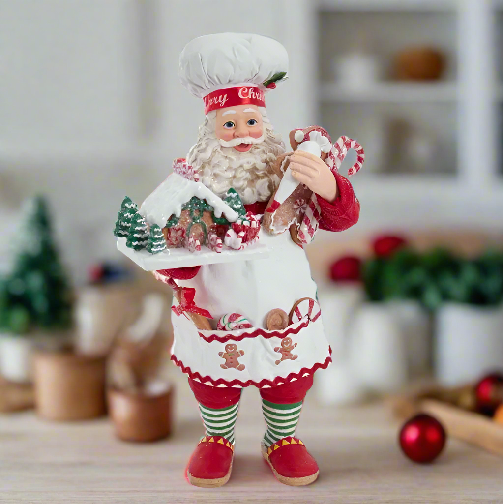 The Canton Christmas Shop 10.5" Fabriché™ Gingerbread Chef Santa with Gingerbread House and Piping Bag