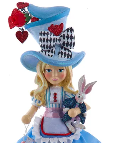 Christmas Cheer All Year 13" Alice in Wonderland nutcracker wearing a blue top hat with red hearts and a black-and-white harlequin bow, holding a white rabbit in a blue suit against a white background.