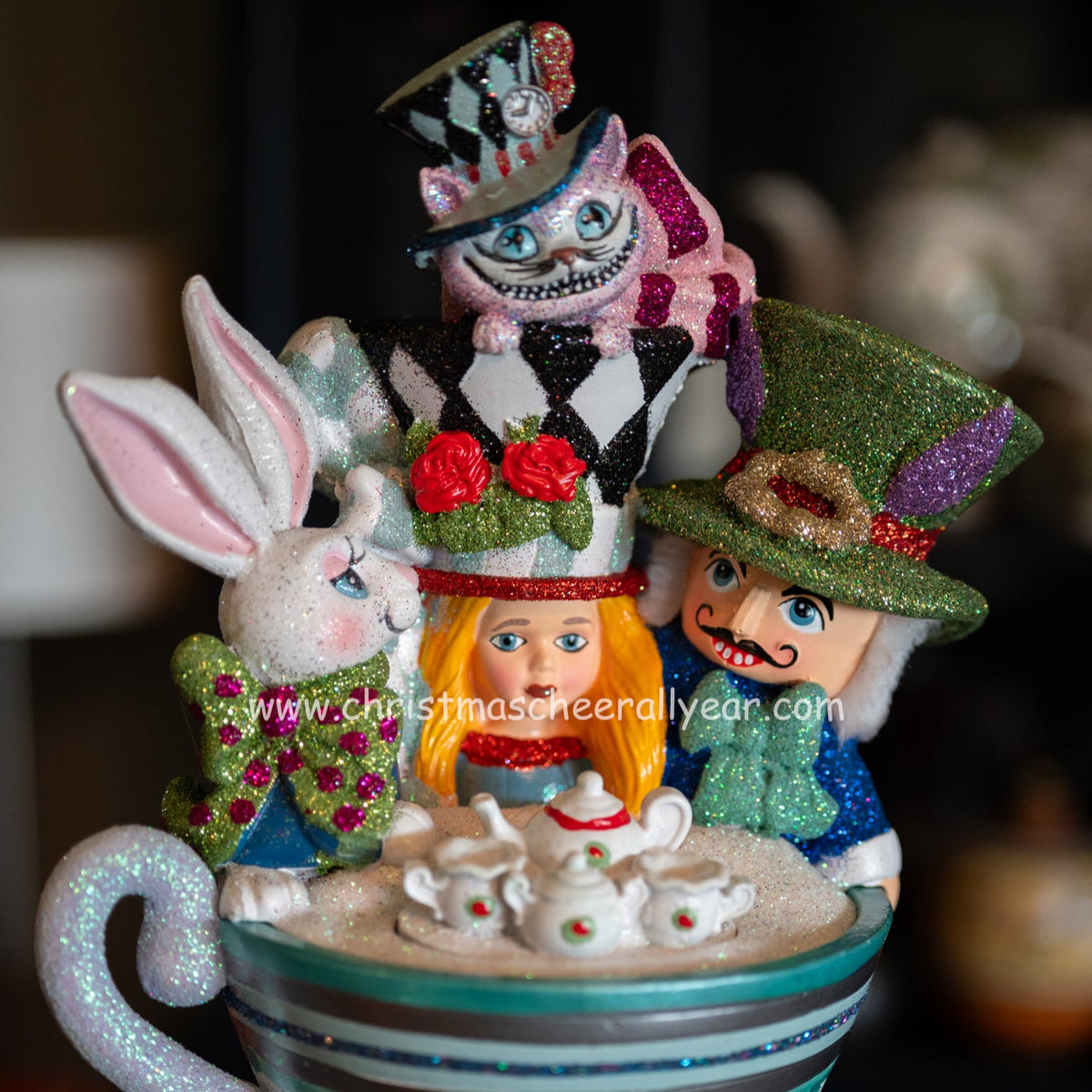 Decorative nutcracker with characters from Alice in Wonderland in a teacup setting.