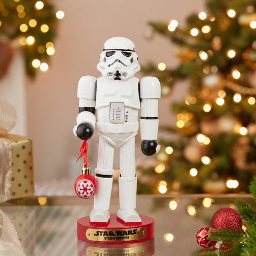 Christmas Cheer All Year Officially Licensed Star Wars Stormtrooper Nutcracker with a Christmas ornament by Kurt Adler in front of a decorated tree
