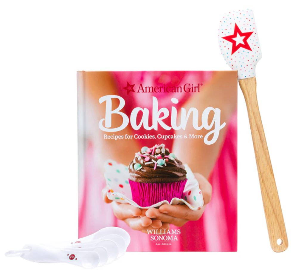 American Girl Baking book with a spatula and spoon rest on a white background