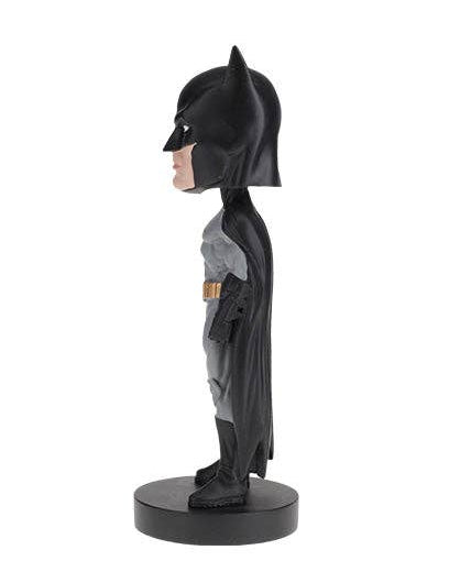 A side-profile collectible bobblehead figure of Batman standing on a round black base against a plain white background.