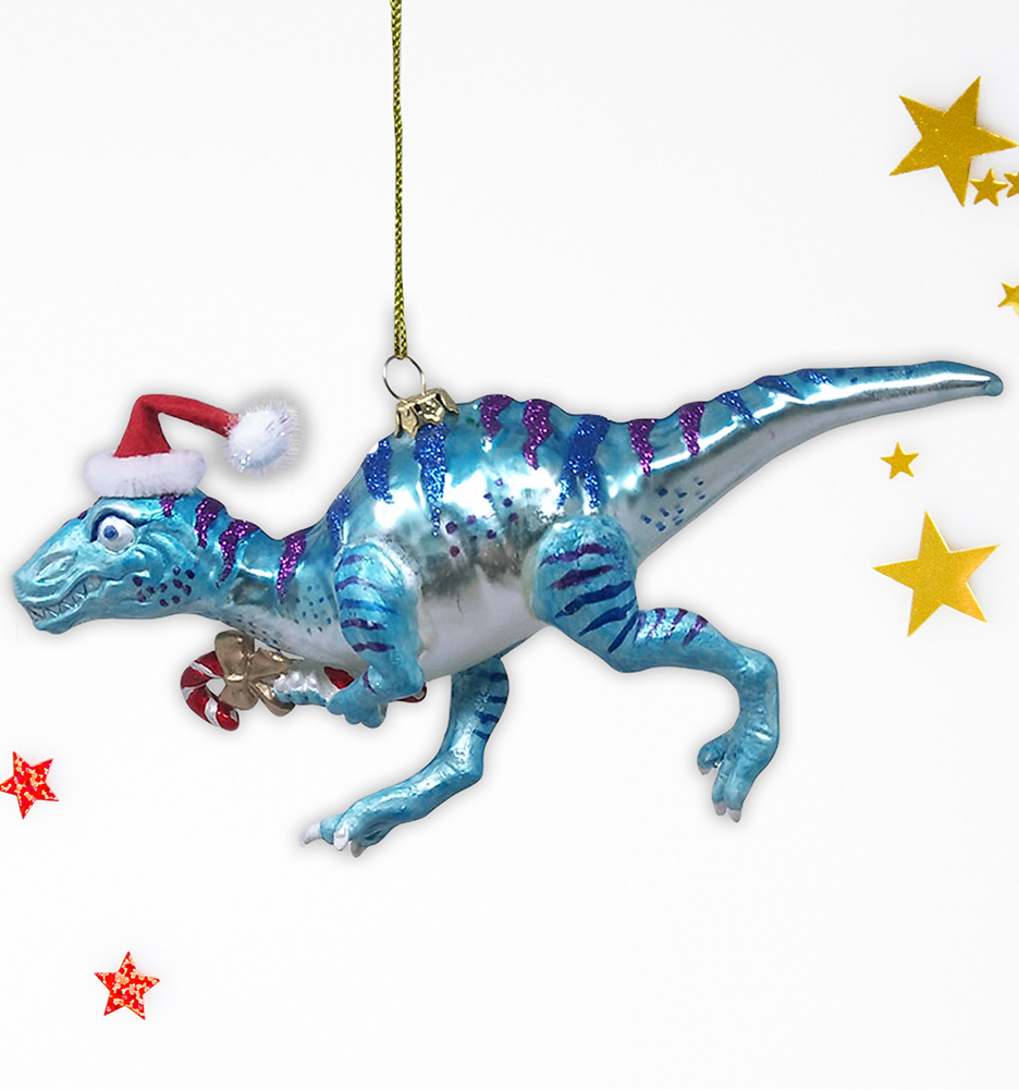 Christmas Cheer All Year Blue dinosaur Christmas ornament with a Santa hat and candy cane, surrounded by decorative stars on a white background.