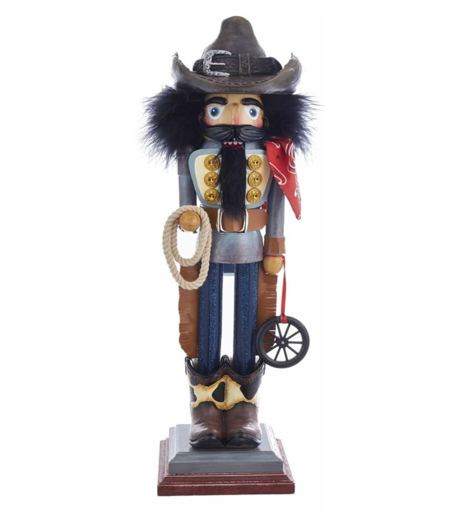 Nutcracker figurine dressed as a cowboy with a lasso and hat on a white background