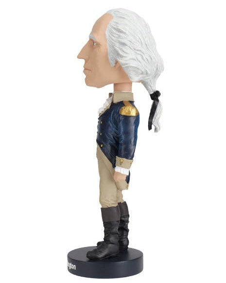 Christmas Cheer All Year George Washington bobblehead-style figurine  in profile, with white hair, a beige face, a dark blue coat with gold shoulder details, tan pants, black boots, and a black round base on a white background.