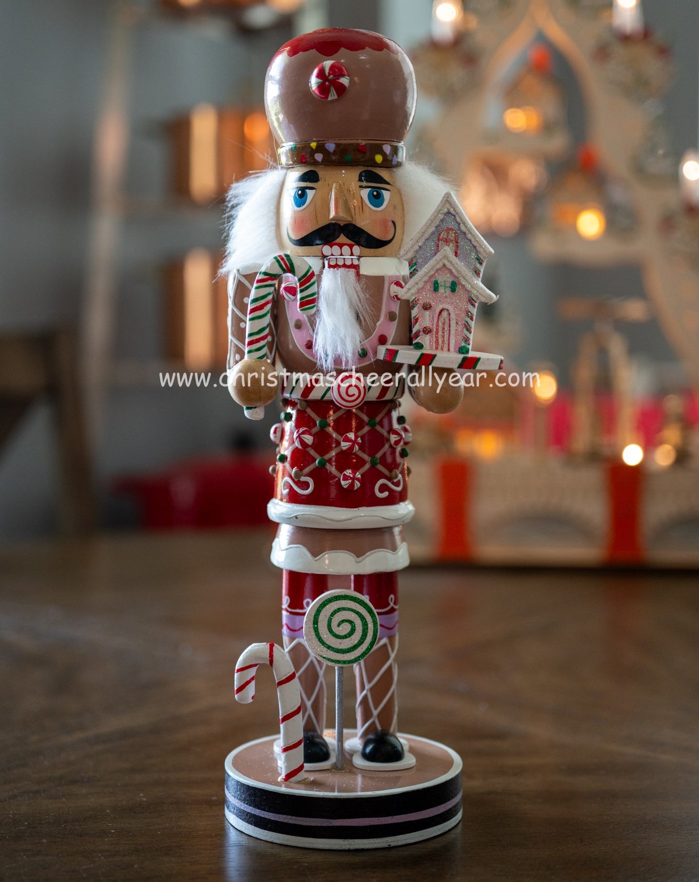 Christmas Cheer All Year Gingerbread Soldier Baker nutcracker with candy cane and gingerbread house and candy cane Kurt Adler all year display