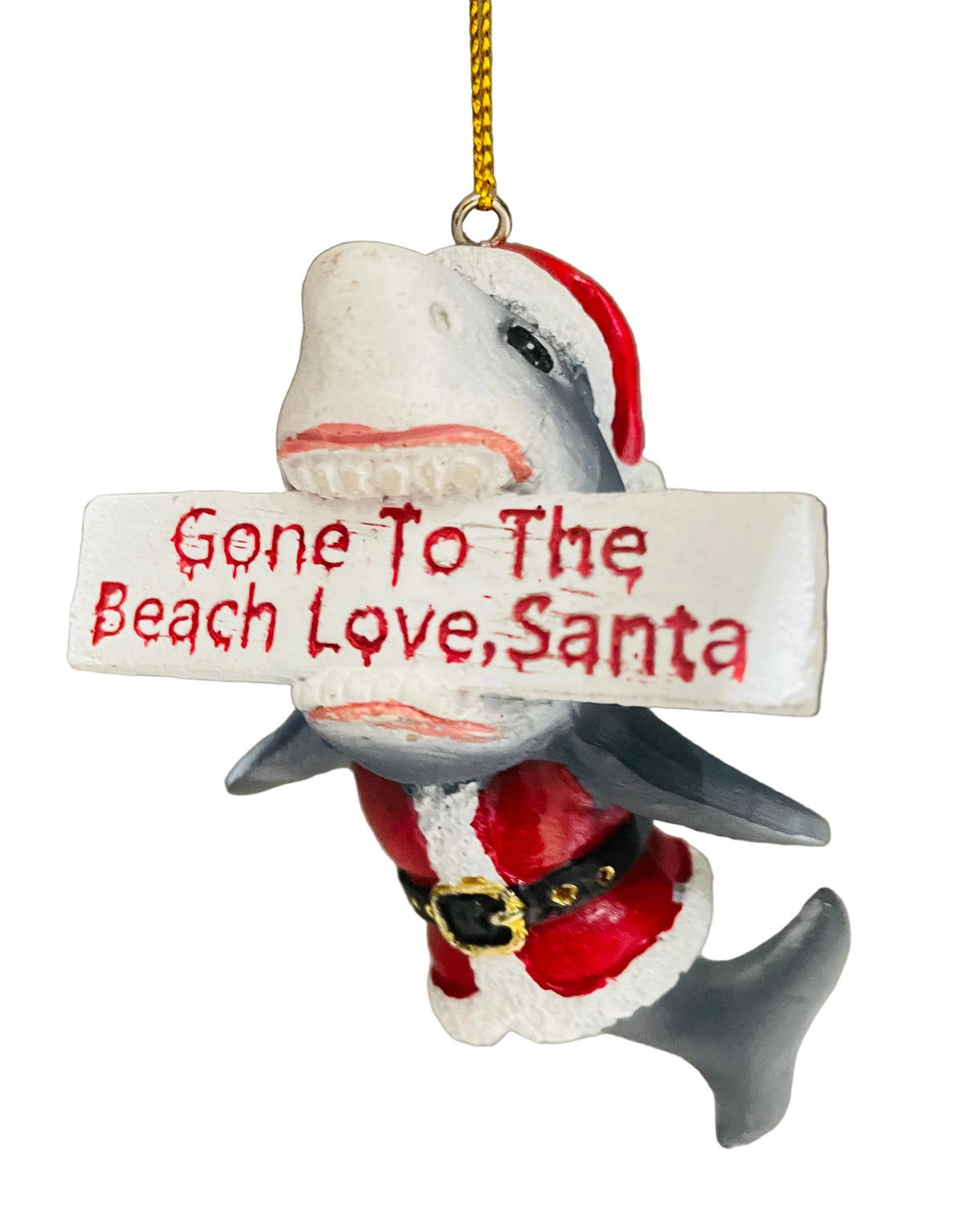A shark-shaped Christmas ornament wearing a Santa hat and Santa suit, holding a white sign that reads 'Gone To The Beach Love, Santa' in red lettering