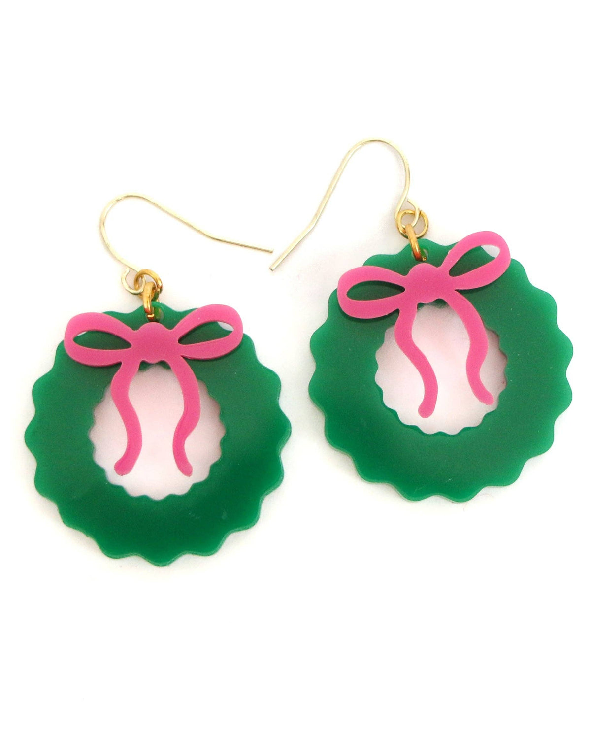 Christmas Cheer All Year pair of green wreath-shaped acrylic dangle earrings with scalloped edges, featuring a pink bow cutout in the center and gold-tone fishhook wires