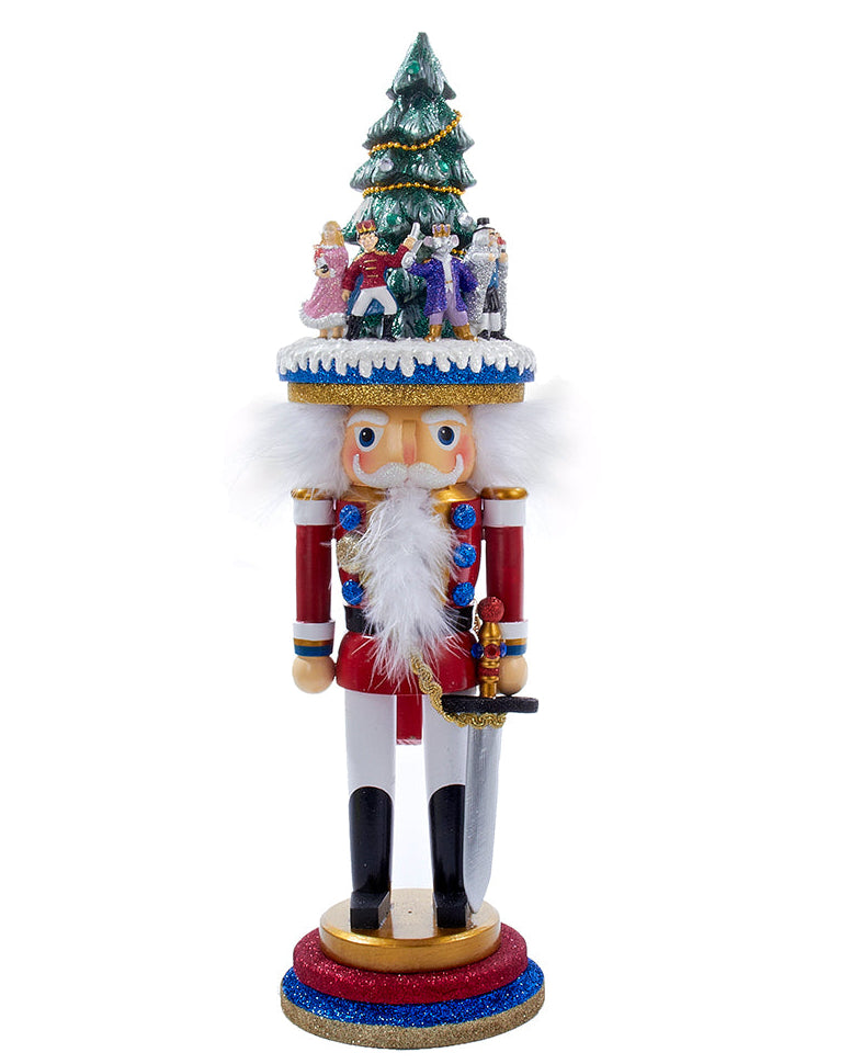 Decorative nutcracker with a Christmas tree and figures on top against a white background