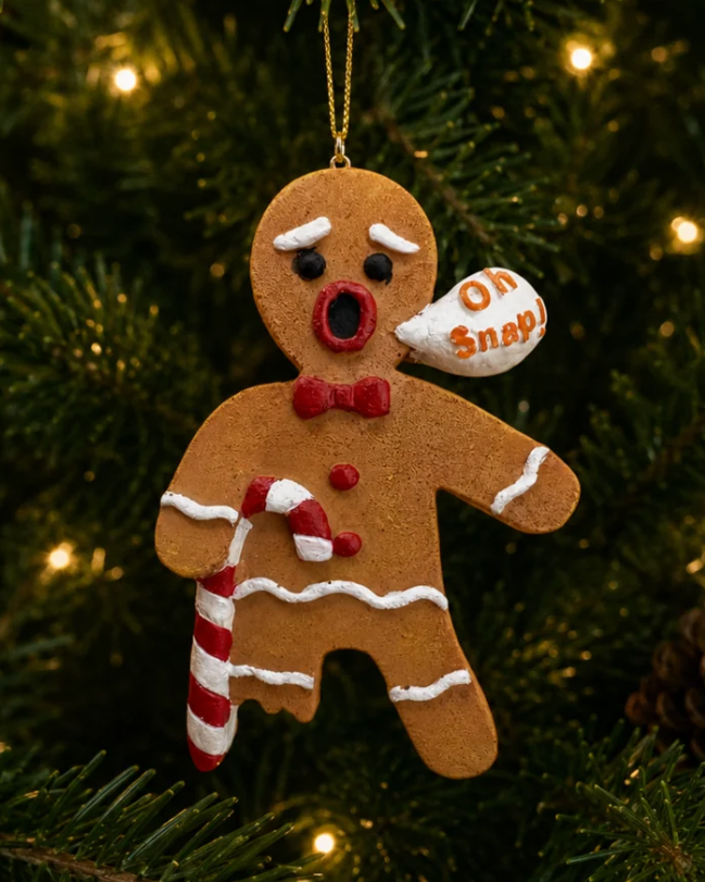 Christmas Cheer All Year gingerbread man Christmas ornament with a surprised face, red bow tie, white icing details, a candy cane, and a small speech bubble that says 'Oh Snap!' with a broken cookie leg hanging on christmas tree