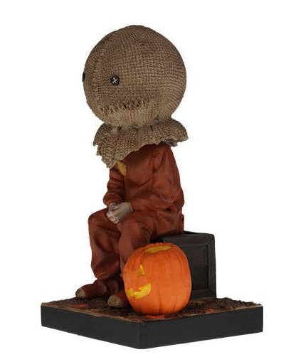 Christmas Cheer All Year Halloween Movie Sam Trick'r'treat film Bobblehead figure of a character with a burlap sack on his head sitting next to a carved pumpkin at his feet 