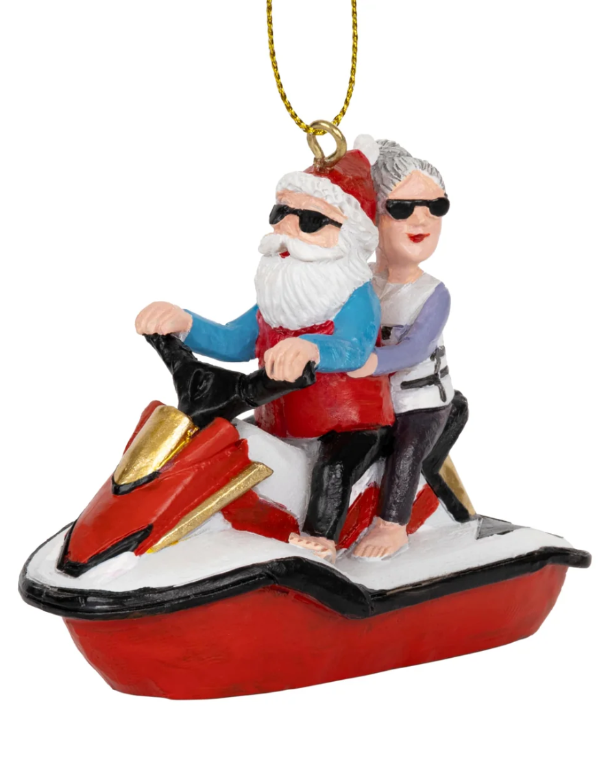 Christmas Cheer All Year Christmas ornament depicting Santa Claus and Mrs. Claus riding a red, gold, black and white jet ski while barefoot wearing sunglasses 