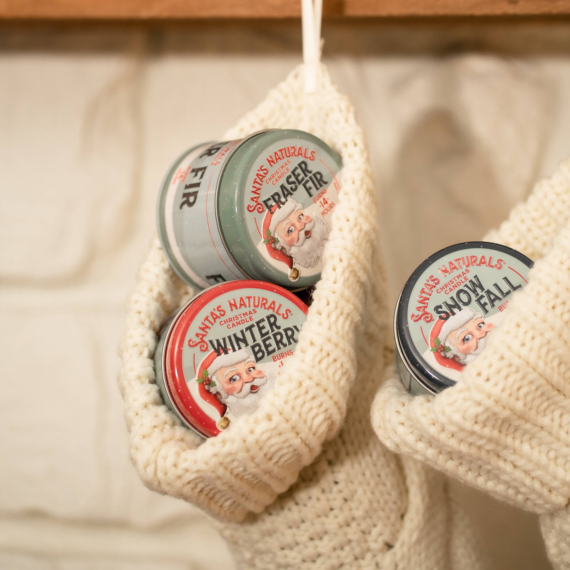 Christmas Cheer All Year Santa's Naturals Christmas candles with various scents in stockings by mantle