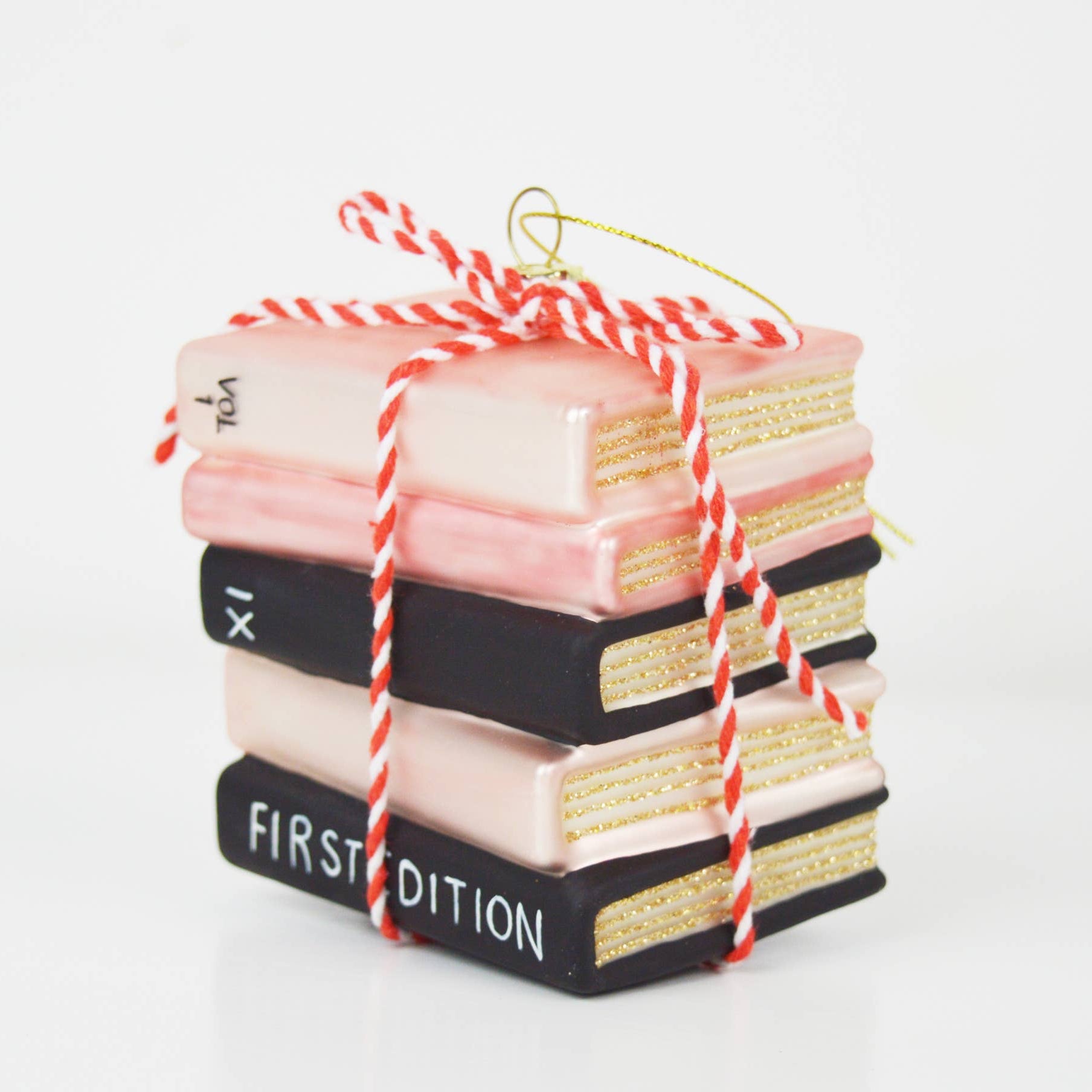 Christmas Cheer All Year Stack of decorative books ornament tied with red and white string on a white background