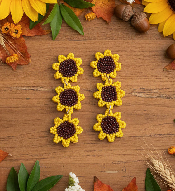 Amanda Bright Designs Sunflower Seed Bead  Earrings on counter with fall foliage