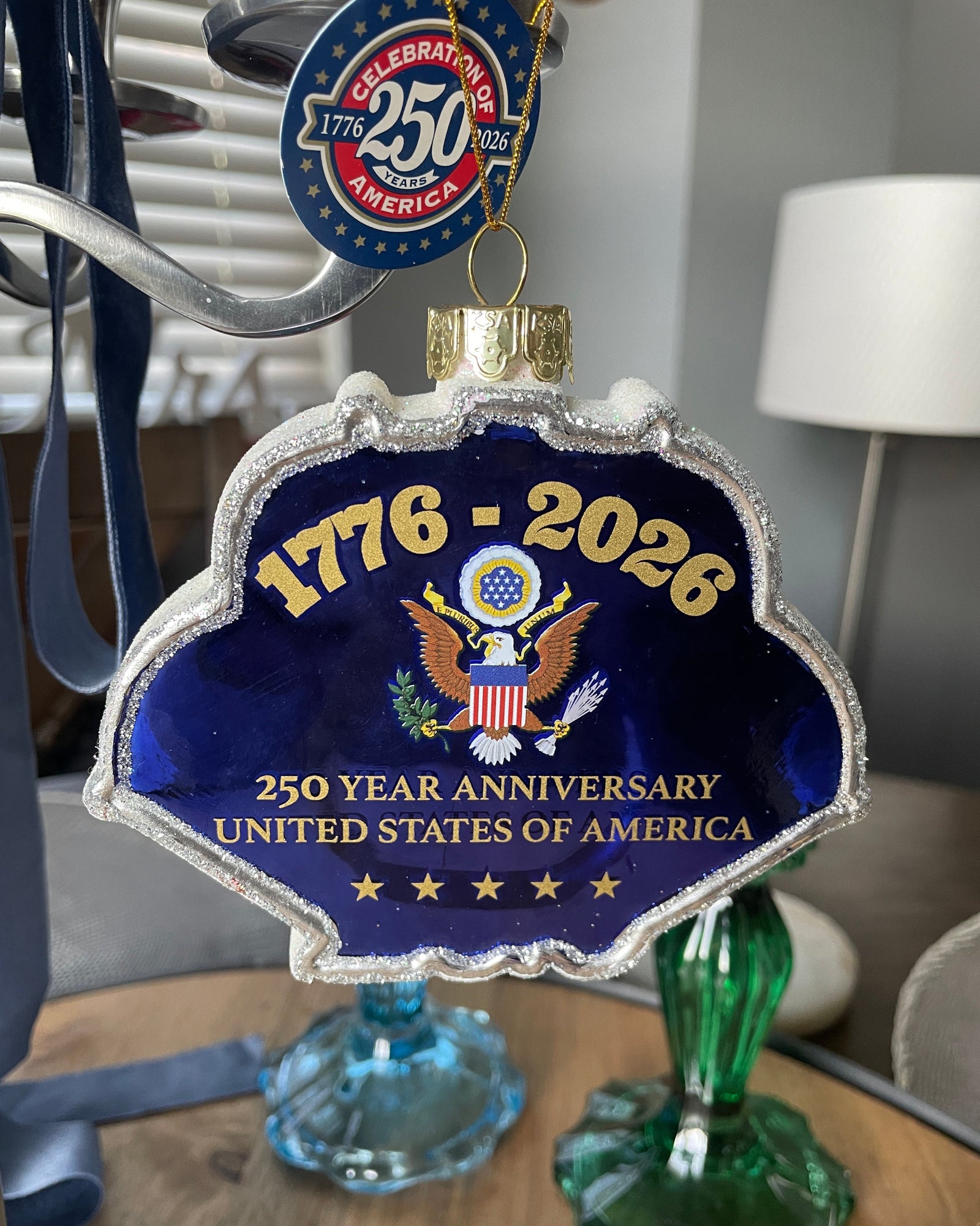 Christmas Cheer All Year Decorative glass Kurt Adler 250th America ornament with '250th Anniversary of the United States' text on a blue background