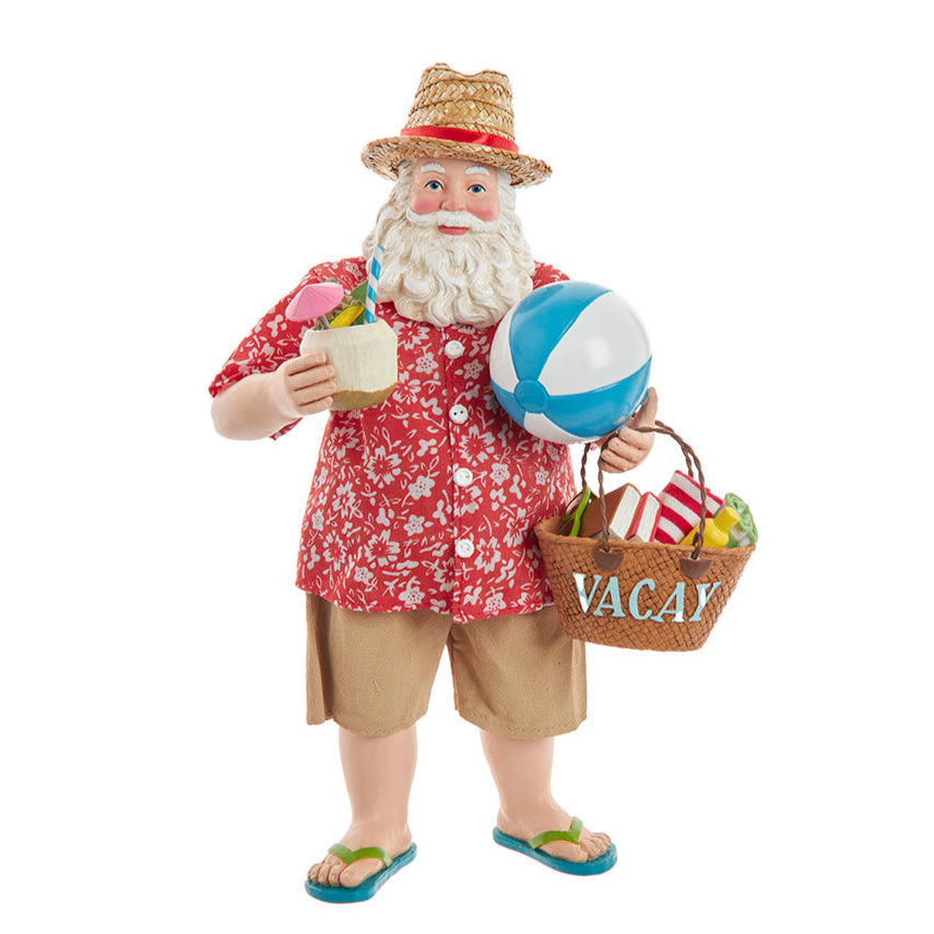 Christmas Cheer All Year Kurt Adler Fabriche Santa Claus figure on a beach holding a drink, beach ball, and 'VACAY' basket.