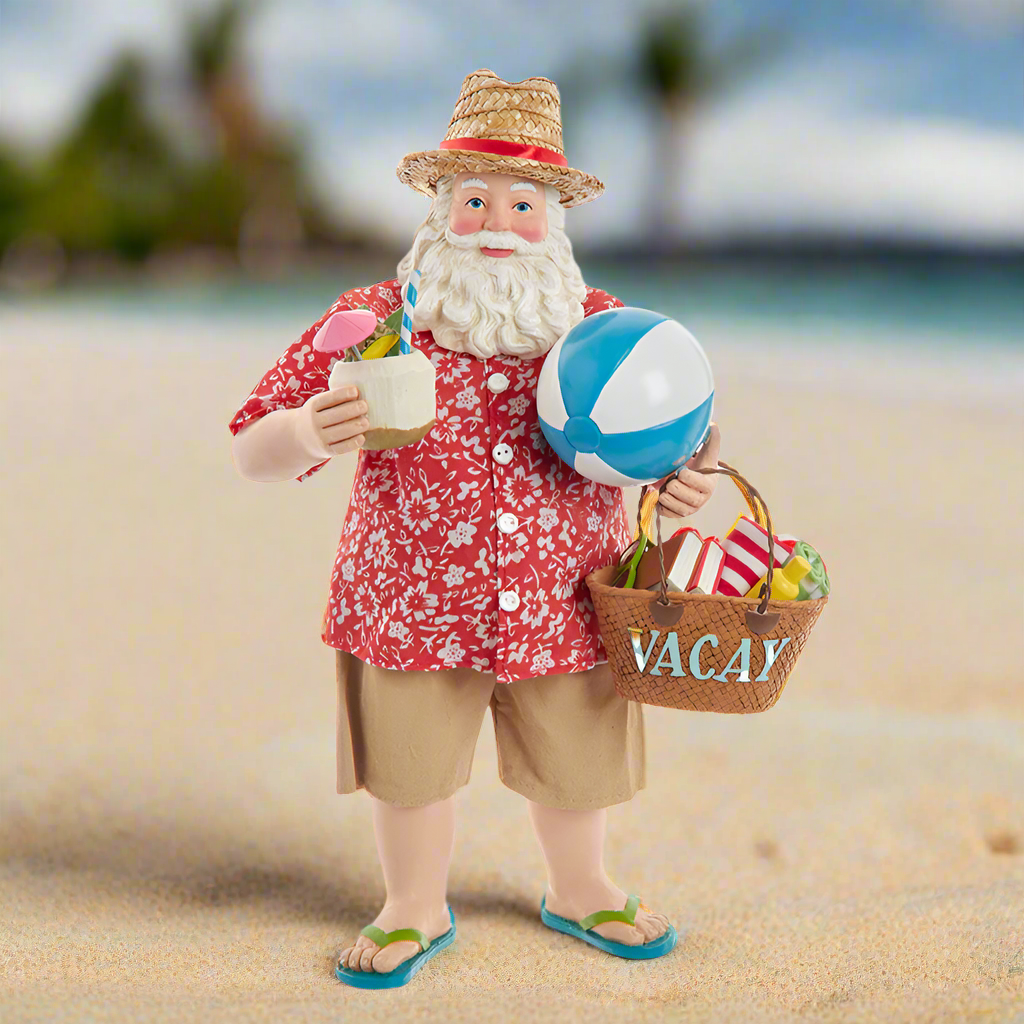 Christmas Cheer All Year Kurt Adler Fabriche Santa Claus figure on a beach holding a drink, beach ball, and 'VACAY' basket.