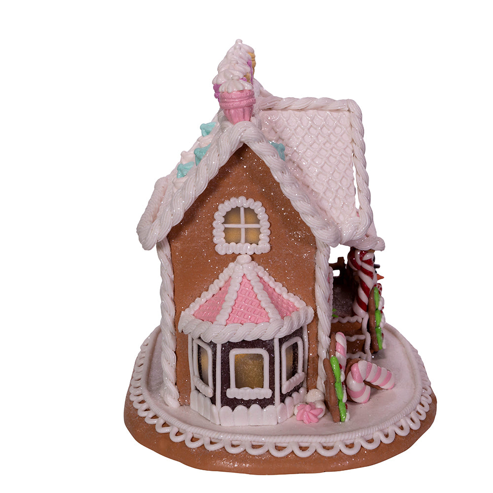 Kurt Adler pink frosted gingerbread house with candy decorations on a white background