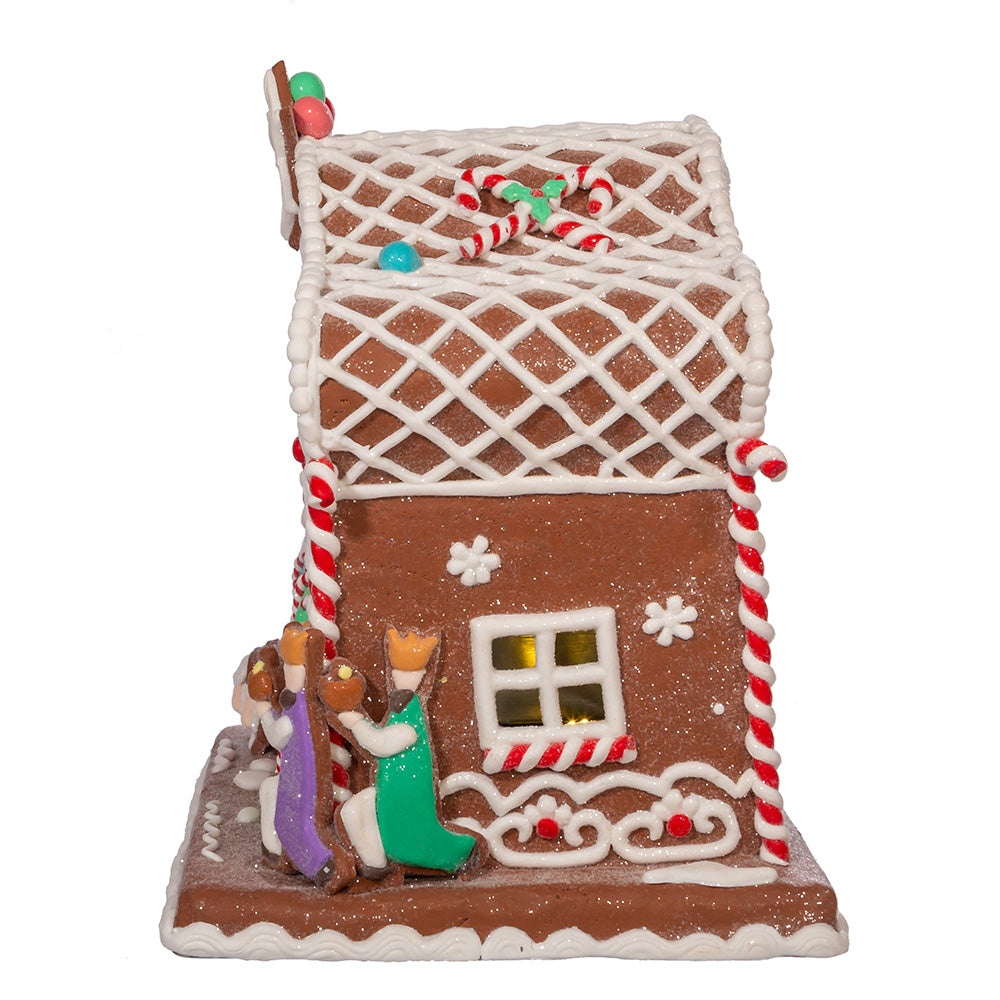 Decorative gingerbread house with three wisemen and candy decorations on a white background