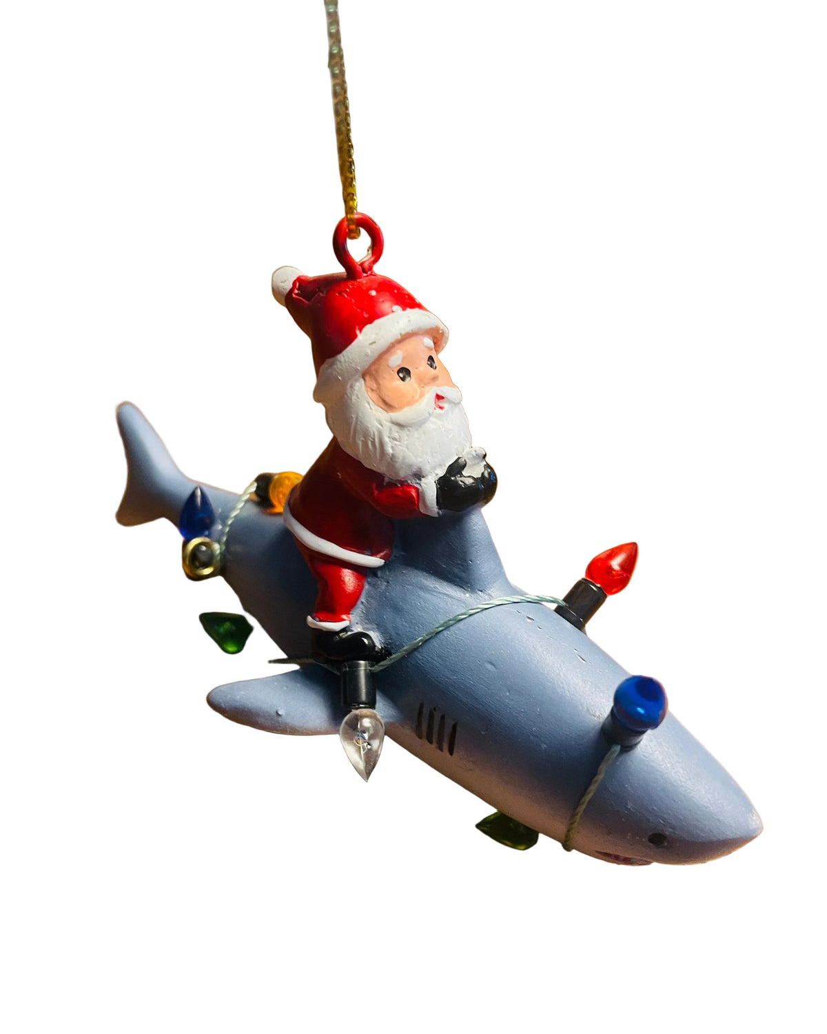 A Santa Claus Christmas ornament riding a gray shark, decorated with colorful Christmas lights