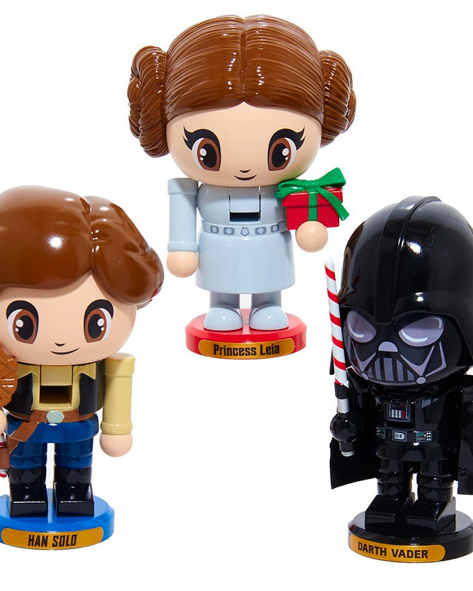 Three chibi-style collectible Star Wars nutcracker figurines on a plain white background: Han Solo on a blue base, Princess Leia on a red base holding a green gift, and Darth Vader on a black base with a candy cane.